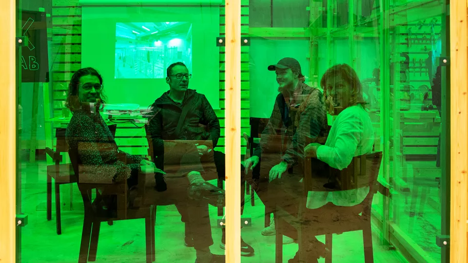 People behind green glass wall