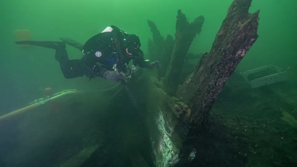 Diver exploring ship on sea bottom