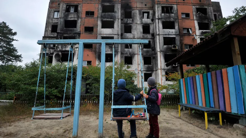 Children stand on a playground in front of a destroyed building in Kalynivka, north of Kyiv. Photo: Sergei Chuzavkov/AFP.