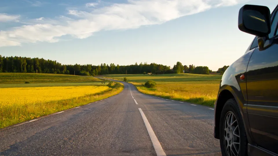 Car driving down a summer road