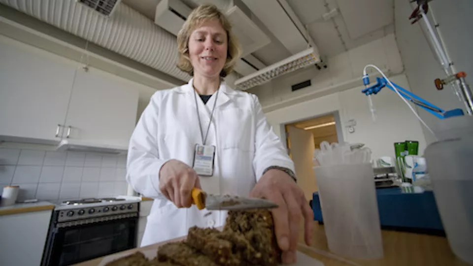 Researcher Anne Nilsson cutting barley bread at her lab. Photo: Kennet Ruona