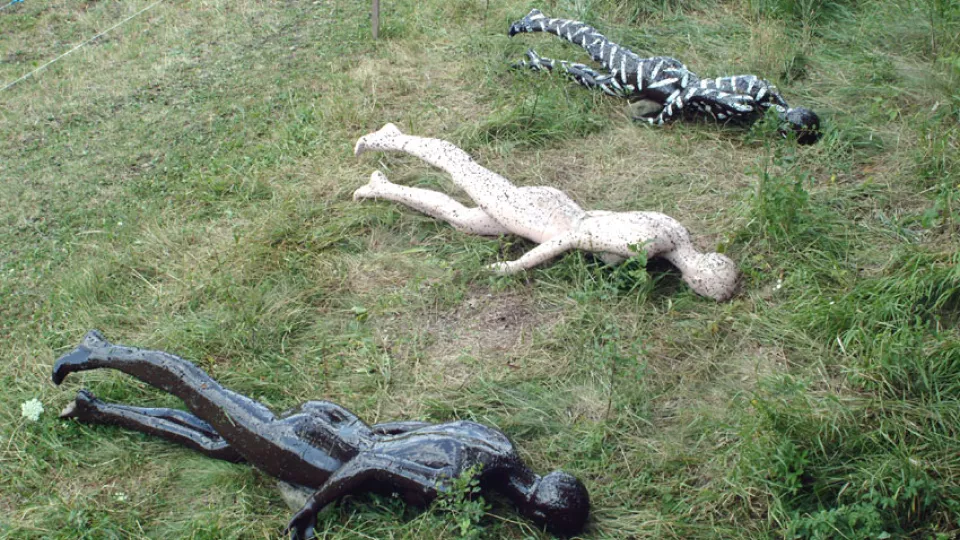 Plastic human models lying in grass 