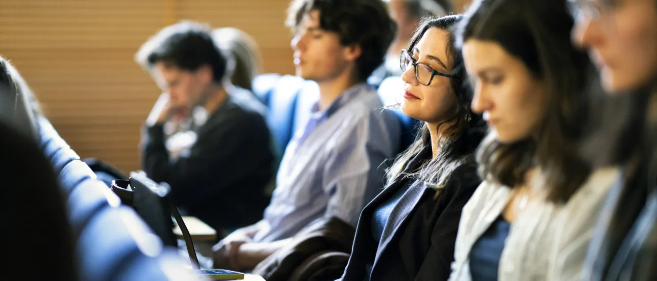 Students sitting listening to a lecture in an auditorium. Photo