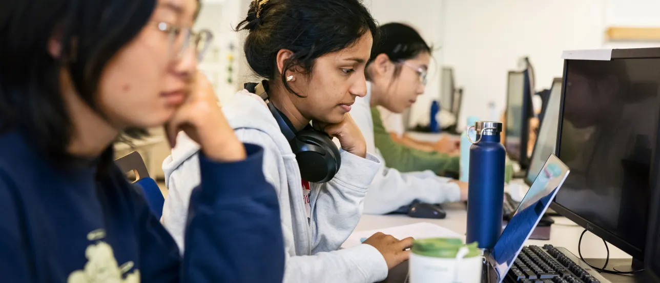 Three students working on their computers.
