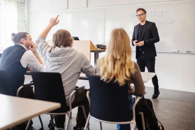 Students in a classroom with a teacher in front of the whiteboard. Photo: Johan Persson.