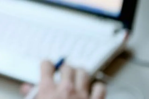 Blurry image of hand browsing on a computer