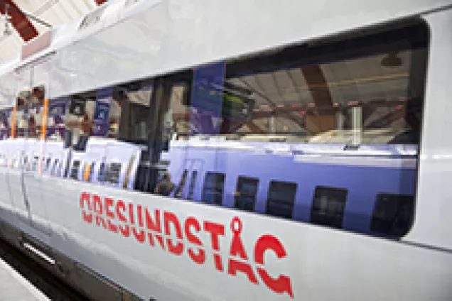 The Öresund train with a reflection of the purple commuter train in its windows