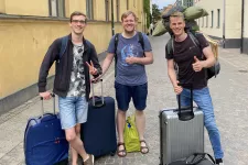 Three students with suitcases on a street in Lund