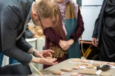 Researchers bending over replicas of the clay tablets