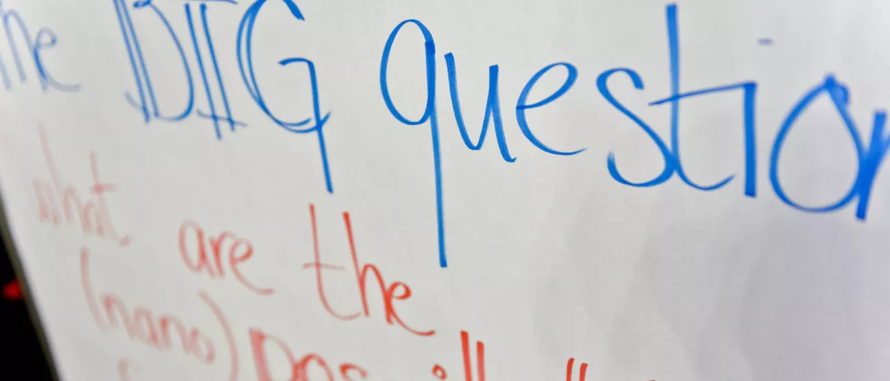 A whiteboard with blue letters that says "the big question"