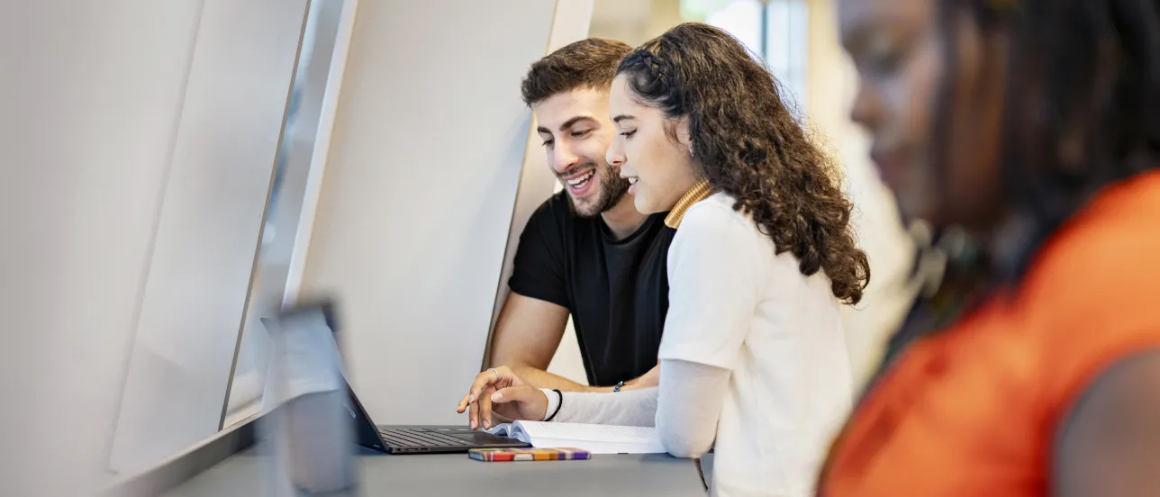 Two students looking at a laptop.