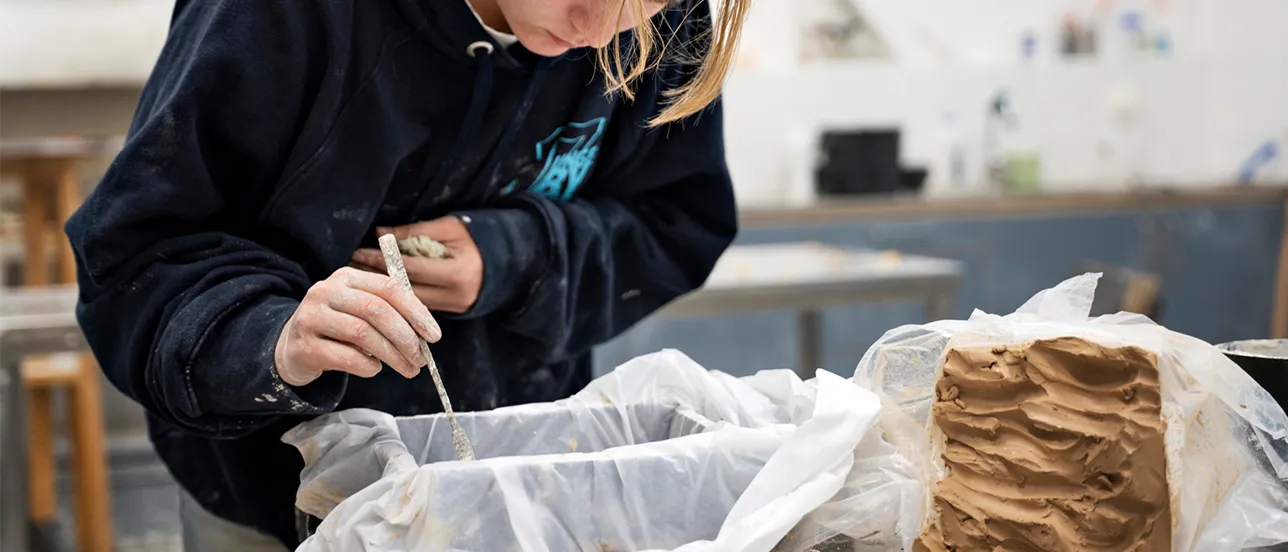 Female student working with clay and moulds. Photo.