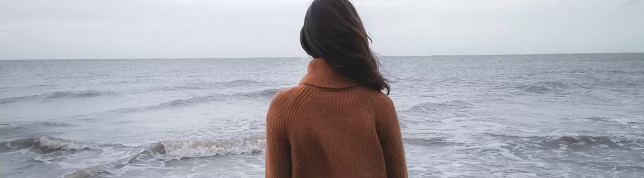 Woman by the sea. Photo: Cosiela Borta/Unsplash.