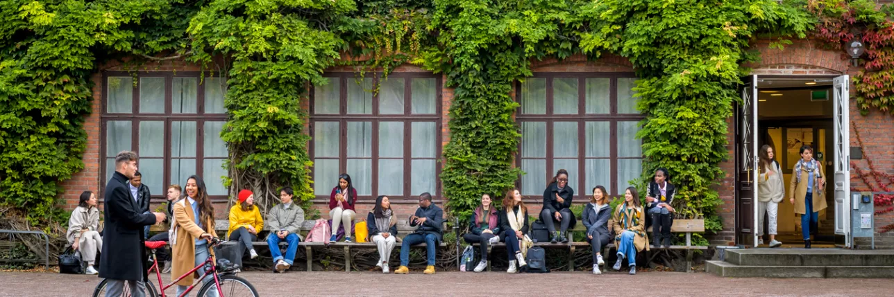 Students sitting on the benches and walking around in front of Palaestra. Photo: Kennet Ruona.