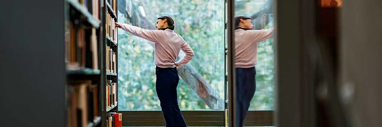Student looking for a book in a Lund University library. Photo.