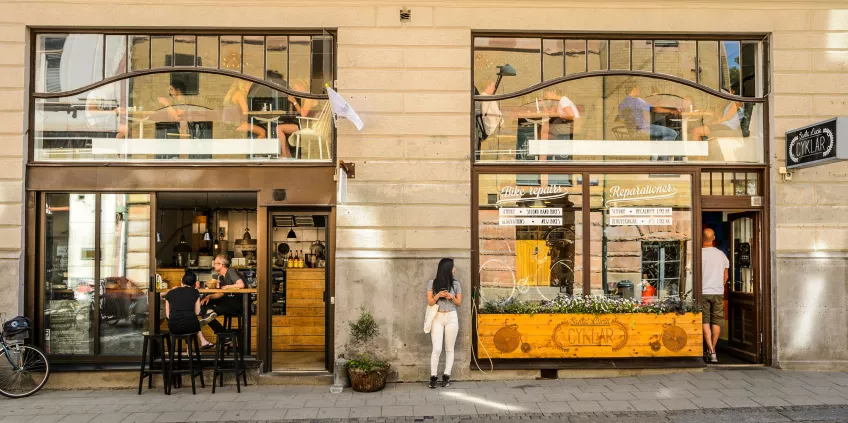 A cafe and a bike shop with people behind the windows