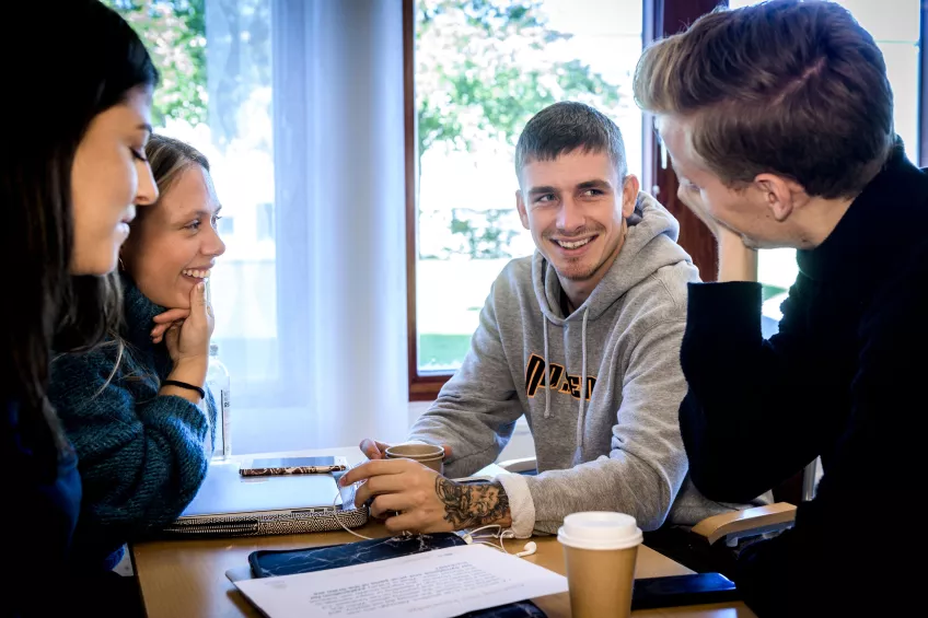 Four students laughing during group work