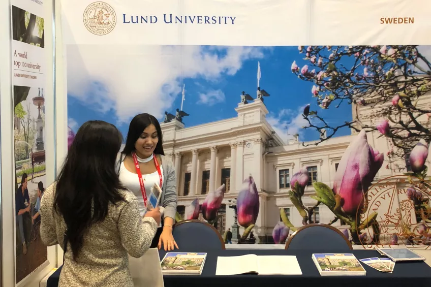 An LU representative talking to a prospective student at an international fair