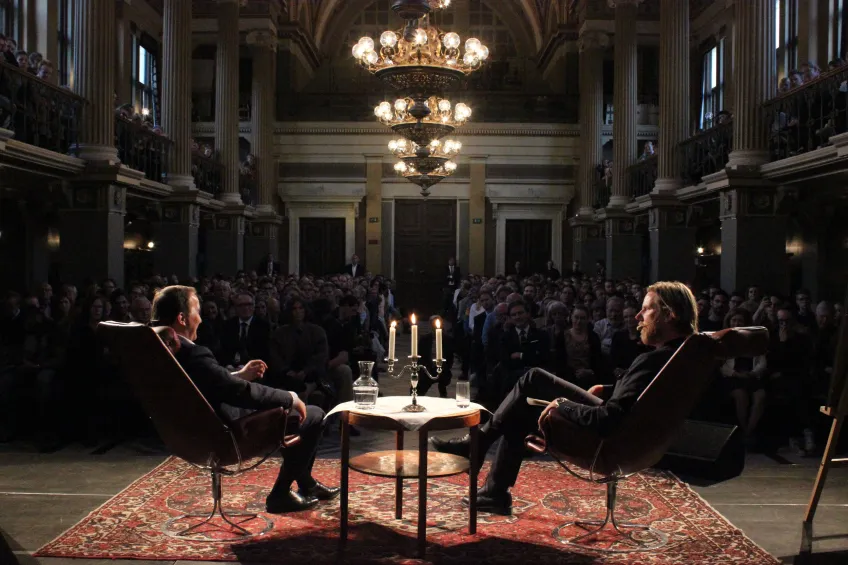 The Studentafton host with distinguished guest in front of the audience inside the Main University Building