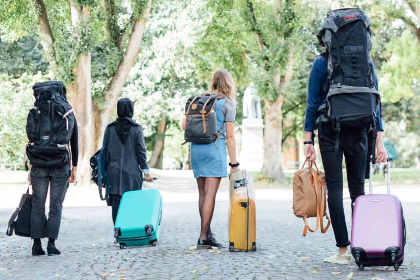 Four students dragging around suitcases and backpacks in the streets of Lund. Photo: Eric Hertz.