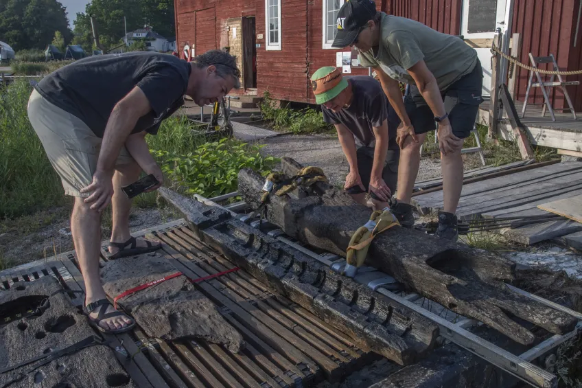 Archaeologists Brendan Foley (Lund University), Mikkel Haugstrup Thomsen and Marie Jonsson (Viking Ship Museum) inspect an artillery bed and ship elements recovered from Gribshunden in 2021