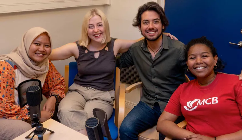 Four students recording a podcast. Photo.